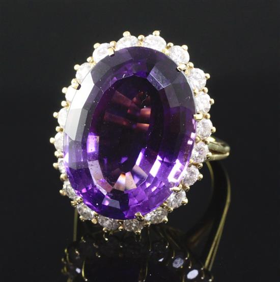 An 18ct gold, amethyst and diamond oval cluster ring, size K.